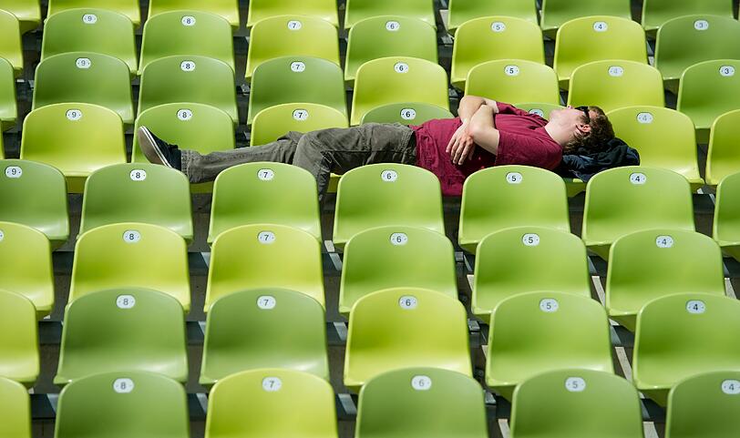 Die Ruhe vor dem Sturm genießt dieser Fan auf der noch leeren Tribüne im Olympiapark, bevor das Pubclic Viewing hier losgeht.