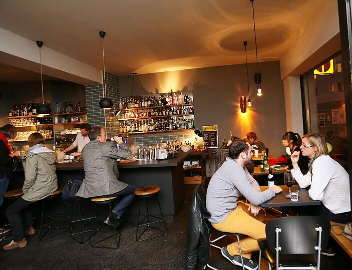 Der niedrige Tresen (hinten im Bild) ist nicht nur bequem zum Essen. Wer hier sitzt, kann auch dem Barkeeper bei der Arbeit zusehen.