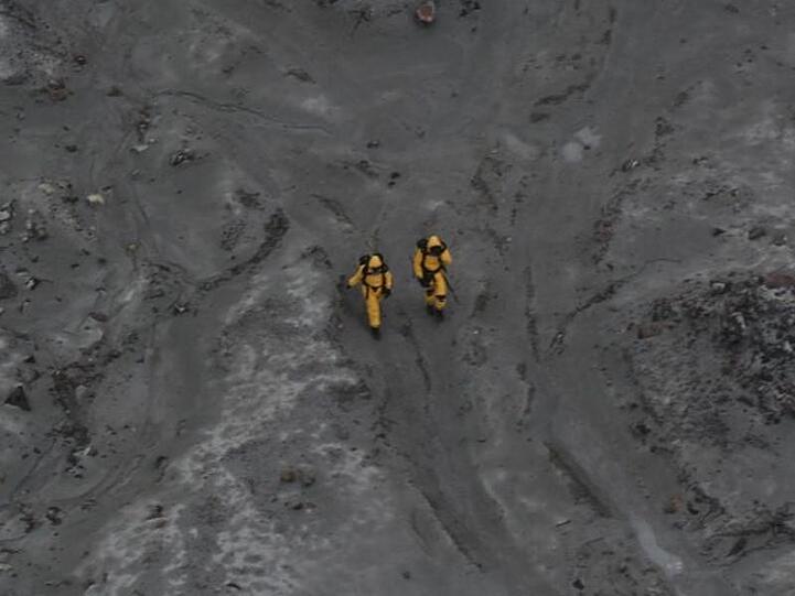 Zwei Mitglieder der Bergungskräfte bei ihrem gefährlichen Einsatz auf der Insel White Island.