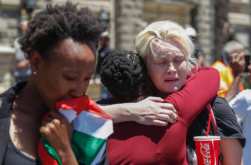 Unterschiedliche Hautfarbe, gleiche Gefühle: Zwei Frauen trauern in Kapstadt um Nelson Mandela.
