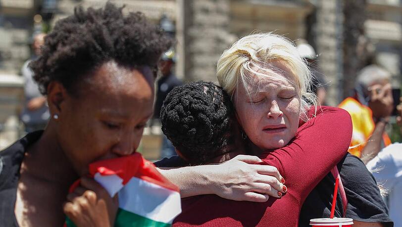 Unterschiedliche Hautfarbe, gleiche Gefühle: Zwei Frauen trauern in Kapstadt um Nelson Mandela. Unterschiedliche Hautfarbe, gleiche Gefühle: Zwei Frauen trauern in Kapstadt um Nelson Mandela.