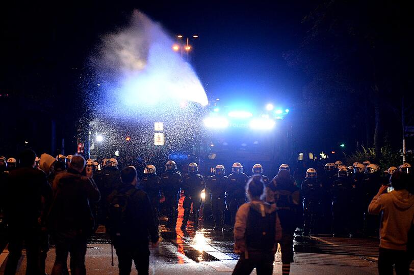 Polizeibeamte und ein Wasserwerfer rücken in Hamburg am Neuen Pferdemarkt im Stadtteil St. Pauli auf der Straße vor. Hunderte Menschen hielten sich auf der Straße auf und behinderten den Verkehr, ehe die Polizei begann, den Neuen Pferdemarkt zu räumen