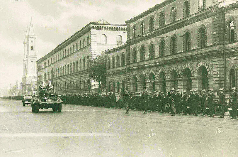 Ludwigstraße: Eisenhower fährt an der amerikanischen Ehrenabordnung vor der Stabi und dem ehemaligen Kriegsministerium vorbei.