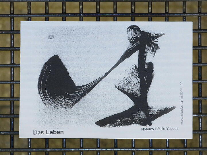 Nobuko Häufle-Yasuda arbeitet mit einem Pinsel und Wasser.