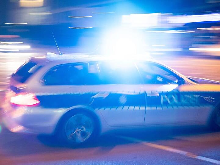Ein Polizeiauto fährt unter Einsatz von Blaulicht und Sirene eine Straße entlang. Foto: Lino Mirgeler/Archiv