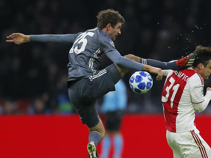 Bayerns Thomas Müller trifft Ajaxs Nicolas Tagliafico (r) mit seinem Fuß am Kopf. Foto: Peter Dejong