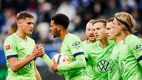 Wolfsburgs Felix Nmecha (M) jubelt mit seinen Mannschaftskollegen über den Treffer zum 1:1.