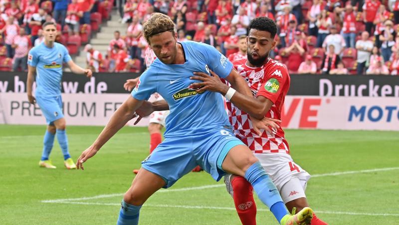 Freiburgs Lucas Höler versucht den Ball vor dem attackierenden Mainzer Jeremiah St. Juste abzuschirmen.