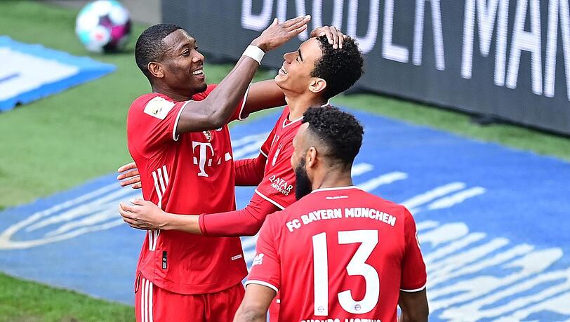 Kopfball ist eigentlich nicht seine Welt, aber Musiala (m.) köpft gegen Wolfsburg ein - sehr zur Freude von Alaba (l.) und Choupo-Moting.
