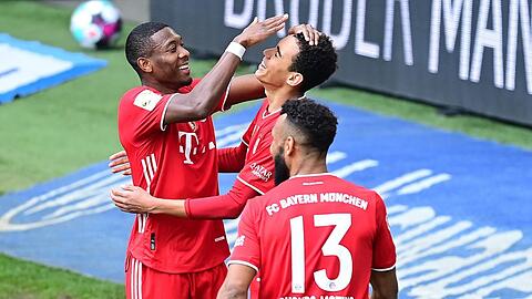 Kopfball ist eigentlich nicht seine Welt, aber Musiala (m.) köpft gegen Wolfsburg ein - sehr zur Freude von Alaba (l.) und Choupo-Moting.