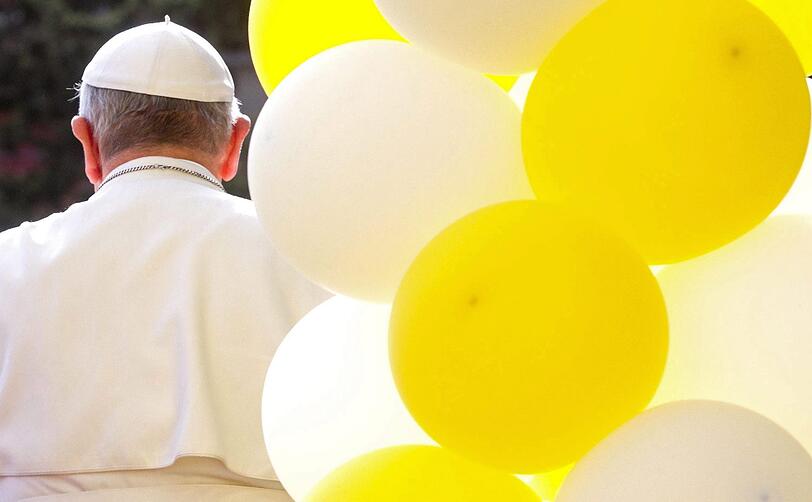 Papst Franz von hinten abgebildet, er hält vor der römischen Pfarrei San Gregorio Magno eine Messe.
