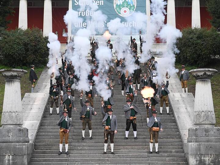 Böllerschützen stehen auf den Stufen der Bavaria und feuern Böllerschüsse ab, die das Ende der Wiesn einläuten. Foto: Felix Hörhager/dpa