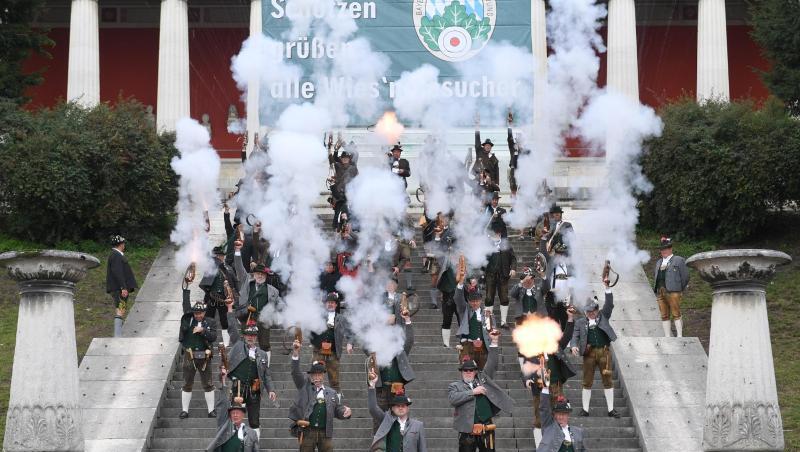 Böllerschützen stehen auf den Stufen der Bavaria und feuern Böllerschüsse ab, die das Ende der Wiesn einläuten. Foto: Felix Hörhager/dpa