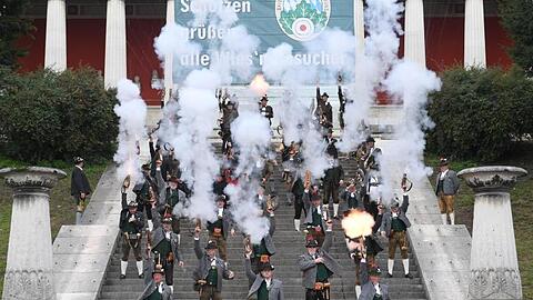 Böllerschützen stehen auf den Stufen der Bavaria und feuern Böllerschüsse ab, die das Ende der Wiesn einläuten. Foto: Felix Hörhager/dpa