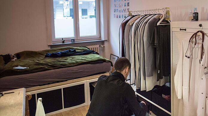Student in seinem WG-Zimmer. Junge Leute leiden oft unter den hohen Mieten in München.
