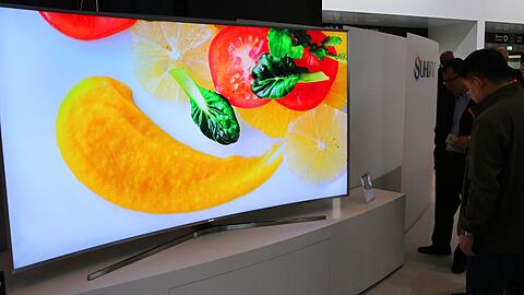 Besucher betrachten auf der IFA 2015 hochaufl&ouml;sende gebogene Flachbildschirme von Samsung.