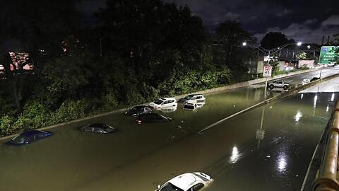 Fahrzeuge stehen im Hochwasser auf einer Straße New Yorks.