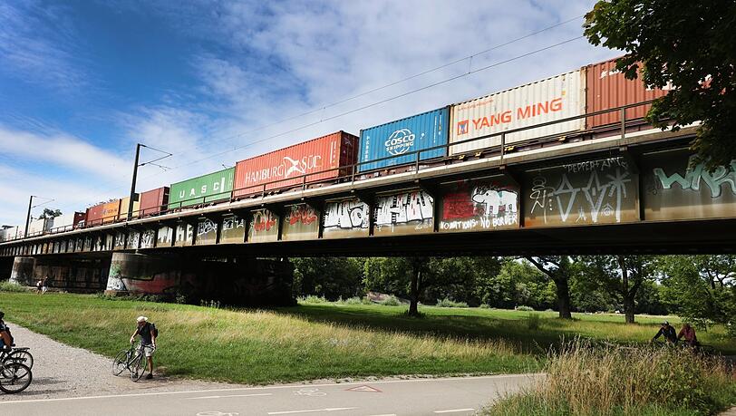 Container aus aller Welt rattern über die Eisenbahnbrücke.