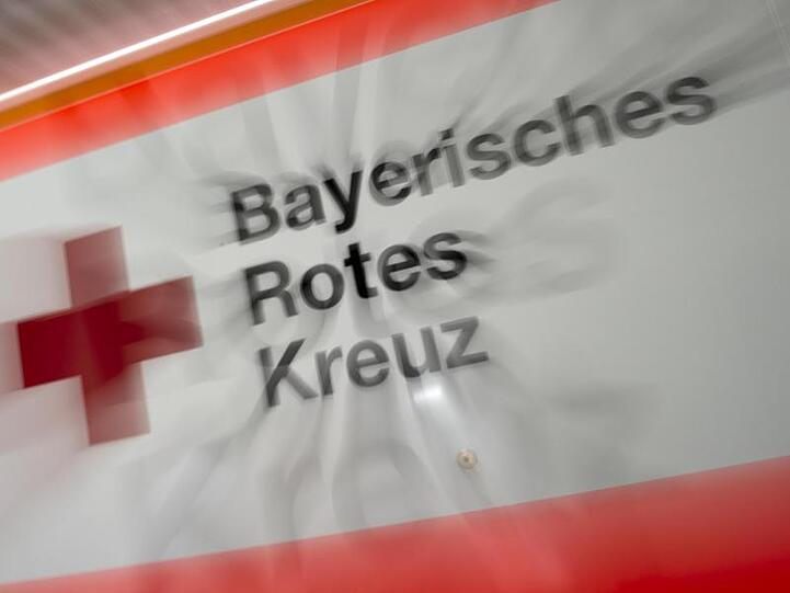 Das Logo des Bayerischen Roten Kreuzes ist an einem Rettungsfahrzeug zu sehen. Foto: Peter Kneffel/dpa