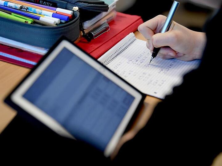 Komplett ausgestattet: Ein Schüler mit Tablet, Stift und Papier im Matheunterricht.