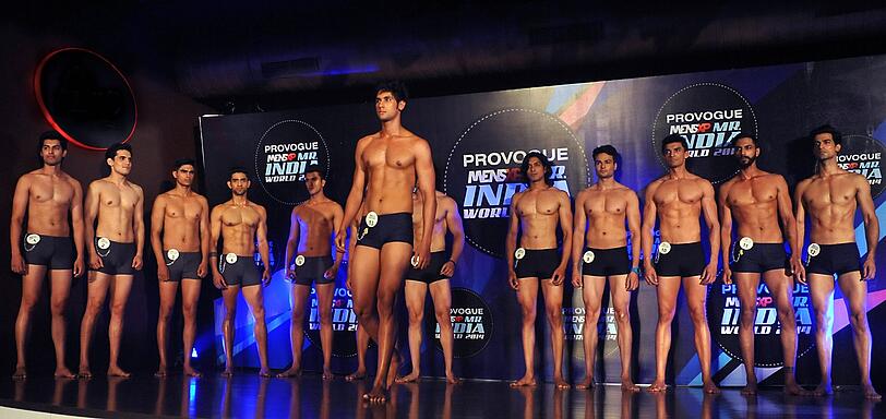 Junge, durchtrainierte Männer stehen bei der Wahl zum Mr. India in Mumbai (Indien) auf dem Laufsteg.