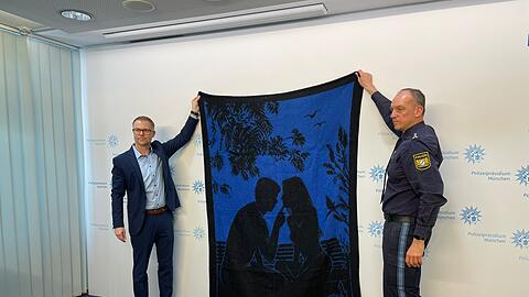 Stephan Beer, Chef der Münchner Mordkommission, und Polizeisprecher Werner Kraus zeigen die schwarzblaue Decke, die im Mordfall Sonja Engelbrecht rekonstruiert werden konnte.