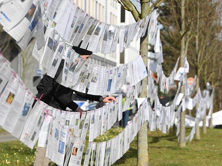 Fotokopien bilden vor dem Wiesbadener Justizzentrum während einer Mahnwache eine "Leine des Grauens" mit angeblichen Gewalttaten von Migranten.