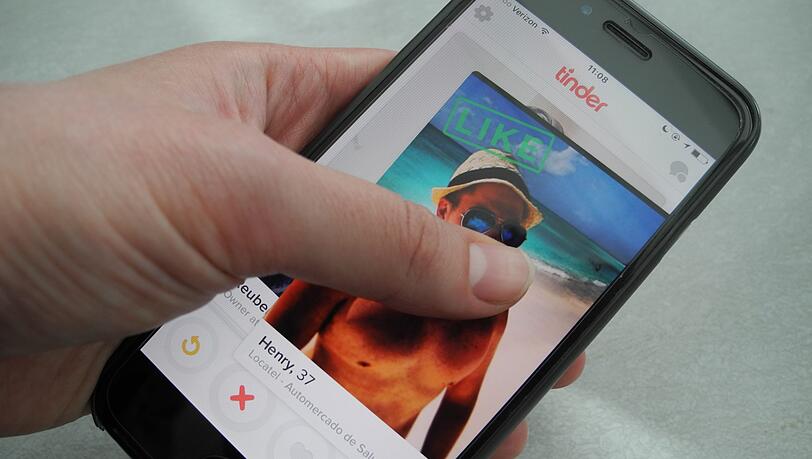 Ein Nutzer hält ein Smartphone auf dem die App Tinder läuft. (Symbolbild) Ein Nutzer hält ein Smartphone auf dem die App Tinder läuft. (Symbolbild)