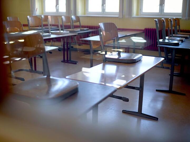 Hochgestellte Stühle stehen in einem Klassenraum. Foto: Britta Pedersen/Archivbild