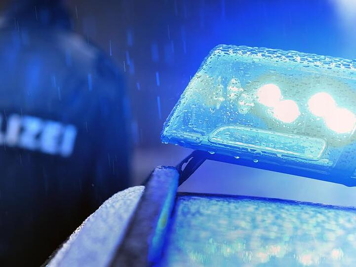Ein Polizist steht vor einem Streifenwagen dessen Blaulicht aktiviert ist. Foto: Karl-Josef Hildenbrand/Archivbild