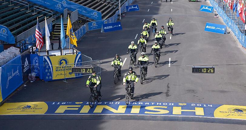 Anders die Situation in Boston: Ein Jahr nach den tragischen Anschlägen auf den Boston Marathon 2013 laufen heute erneut tausende Menschen die knapp 41 Kilometer lange Strecke. Dabei wurde in diesem Jahr die Anzahl der Polizisten deutlich erhöht.