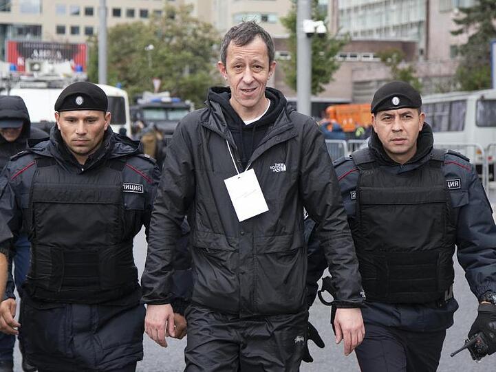 Anton Chernyak (M), Rapper und Mitglied der russischen Rapgruppe "Krovostok", verlässt nach einem Auftritt flankiert von Polizisten den Protest.