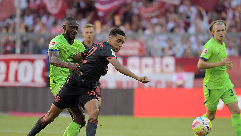 Bayerns Jamal Musiala im Zweikampf gegen Josuha Guilavogui vom VfL Wolfsburg.