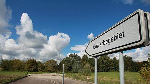 Ein Hinweisschild mit der Aufschrift "Gewerbegebiet" vor einer unbebauten Sackgasse. Foto: Jens Wolf/Archiv