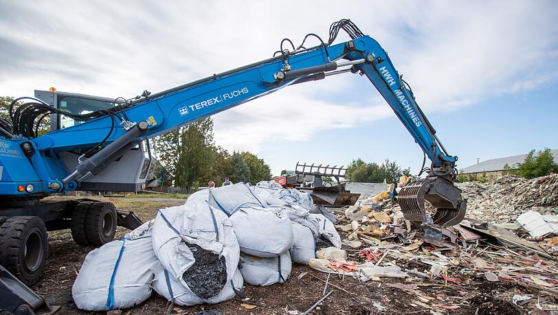 Ein Bagger häuft Müll auf. Eine deutsche Abfallfirma soll illegal Müll entsorgt haben, der nun vom Freistaat Bayern zurückgeholt werden muss.