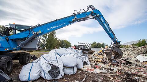 Ein Bagger häuft Müll auf. Eine deutsche Abfallfirma soll illegal Müll entsorgt haben, der nun vom Freistaat Bayern zurückgeholt werden muss.