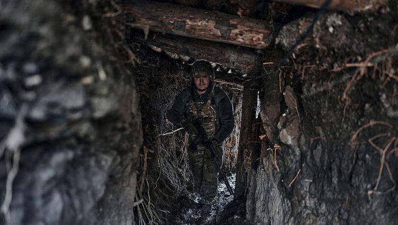 Ein ukrainischer Soldat steht in einem Schützengraben an der Frontlinie im Osten der Ukraine. Ein ukrainischer Soldat steht in einem Schützengraben an der Frontlinie im Osten der Ukraine.