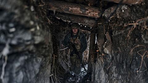 Ein ukrainischer Soldat steht in einem Schützengraben an der Frontlinie im Osten der Ukraine.