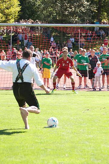 Fußball - in Pähl auch mal in der Krachledernen und barfuß ausgeführt. So Werner Grünbauer, der Bürgermeister von Pähl, beim Elfmeterschießen gegen Torwart Thomas Müller. Ob's an der Lederhosen lag, dass der Schuss weit übers Tor hinaus ging?