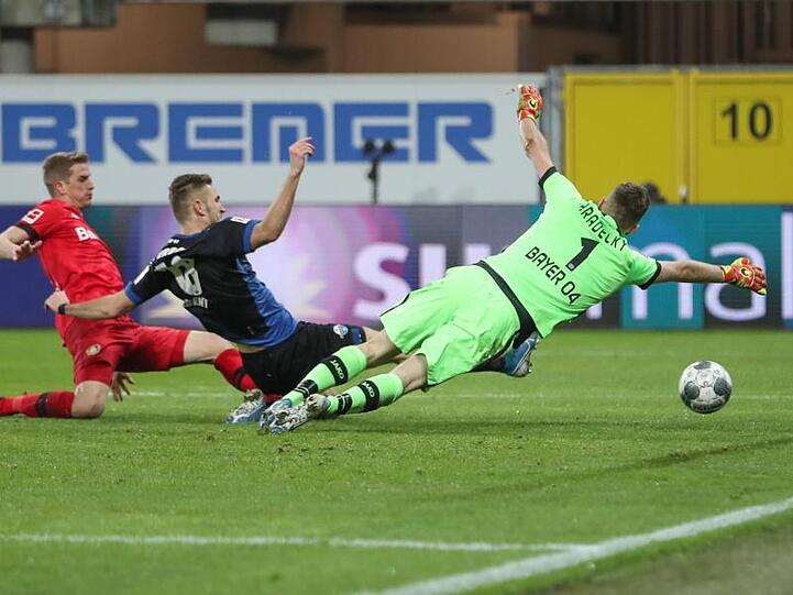 Paderborns Srbeny (M) erzielt den Treffer zum zwischenzeitlichen 1:3 - Bayers Schlussmann Hradecky streckt sich vergebens.