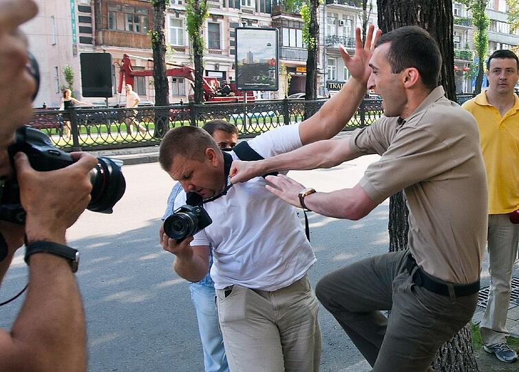 Diesen Fotografen packt der aggressive Ordnungshüter am Kragen und ...
