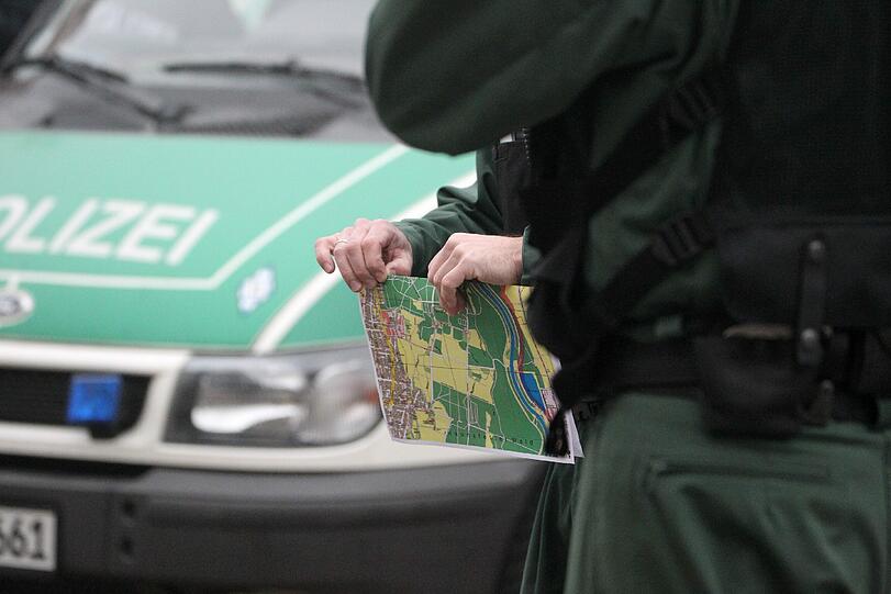 Einen Plan des Gebiets Siebentischwald hält dieser Beamte in der Hand: Ein Sondereinsatzkommando aus München ist auch im Einsatz
