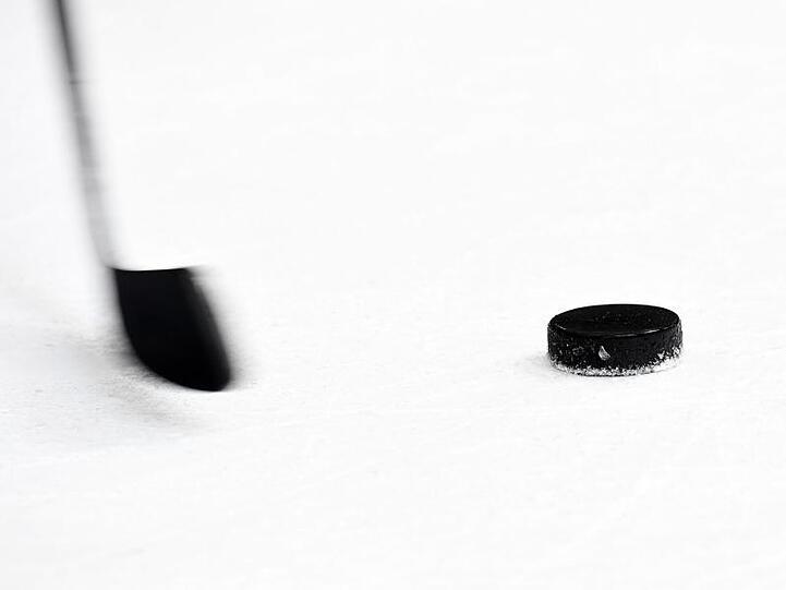 Ein Puck und ein Eishockeyschläger. Foto: Tobias Hase/dpa/Symbolbild
