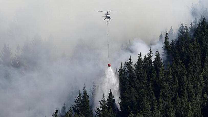 Ein Löschhubschrauber entlädt in der Nähe von Christchurch seinen Wassersack. Ein Löschhubschrauber entlädt in der Nähe von Christchurch seinen Wassersack.