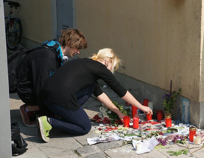 Freunde legen Blumen und Kerzen am Bahnhof in Feldkirchen nieder