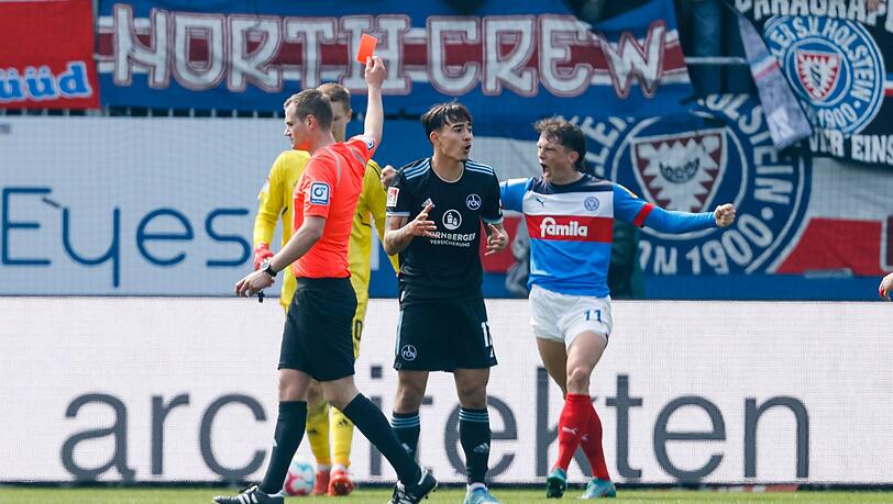 Schiedsrichter Robin Braun (l) zeigt Nürnbergs Jens Castrop (M) die Rote Karte.