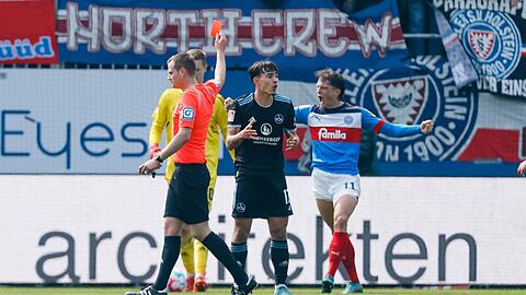 Schiedsrichter Robin Braun (l) zeigt Nürnbergs Jens Castrop (M) die Rote Karte.