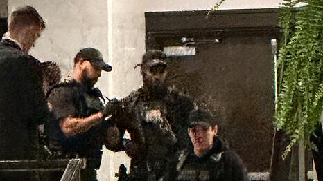 Sicherheitskr&auml;fte umringten eine am Boden liegende Person.