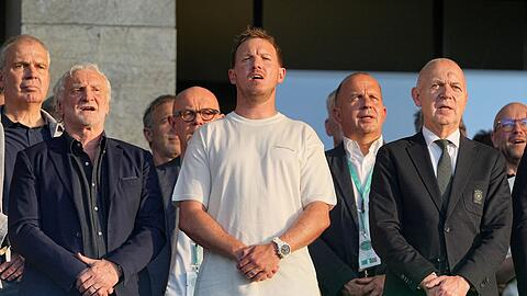 Julian Nagelsmann (m.) steht zwischen DFB-Sportdirektor Rudi V&ouml;ller (l.) und Verbandschef Bernd Neuendorf (r.) auf der Trib&uuml;ne des Berliner Olympiastadions.