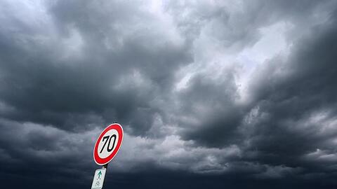Eine dunkle Wolkenfront zieht hinter einem noch in der Sonne liegenden Feldweg auf. Foto: Karl-Josef Hildenbrand/Archiv